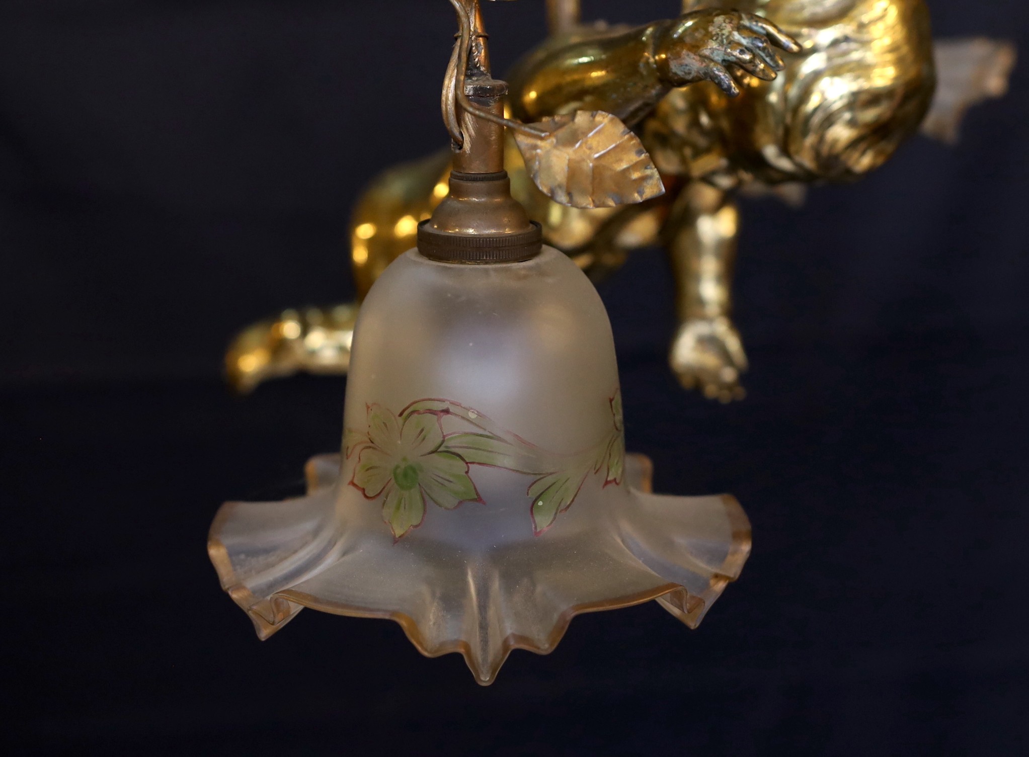 A 1920s French gilt bronze and wrought iron ceiling light with putto and rose motifs, drop 71cm. width 44cm